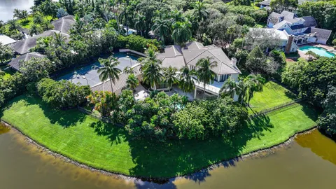 an aerial view of residential house with outdoor space and trees all around
