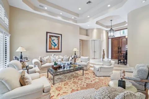 a living room with furniture a large window and a chandelier