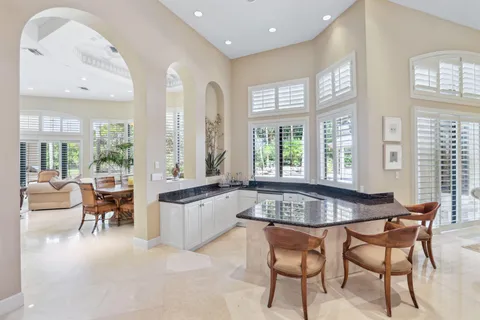 a dining room with furniture and large windows