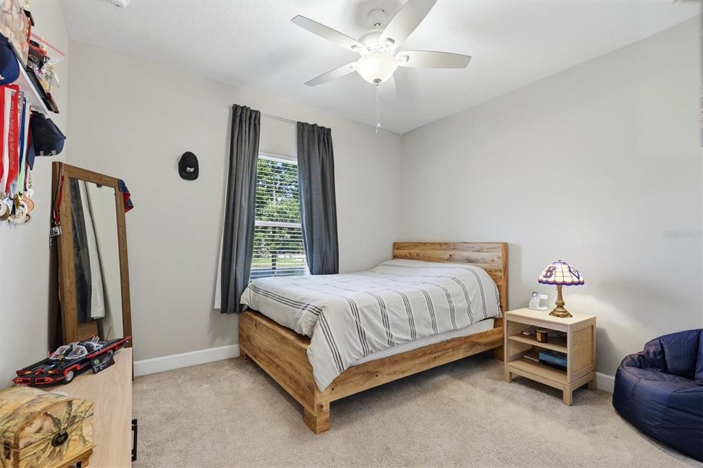 9268 Tequila Sunrise Drive Sarasota, FL 34241 - Photo 24 of 56 a spacious bedroom with a bed and a chandelier