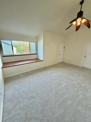 an empty room with a chandelier fan