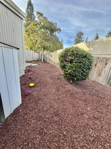 a view of a backyard with wooden fence