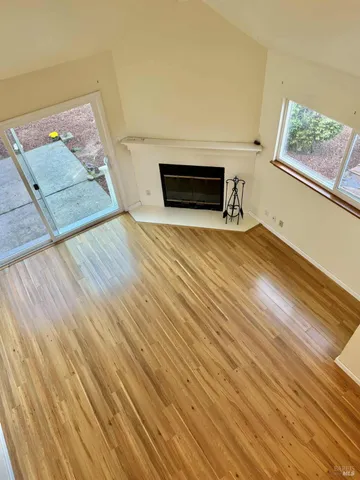 a view of empty room with wooden floor and fireplace