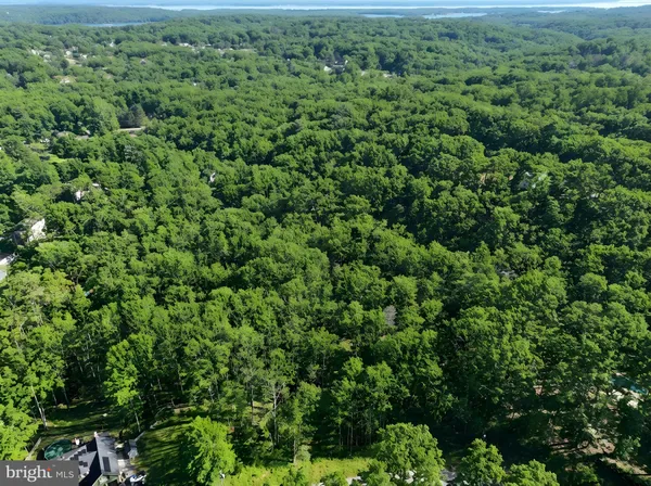 an aerial view of residential house with outdoor space and trees all around