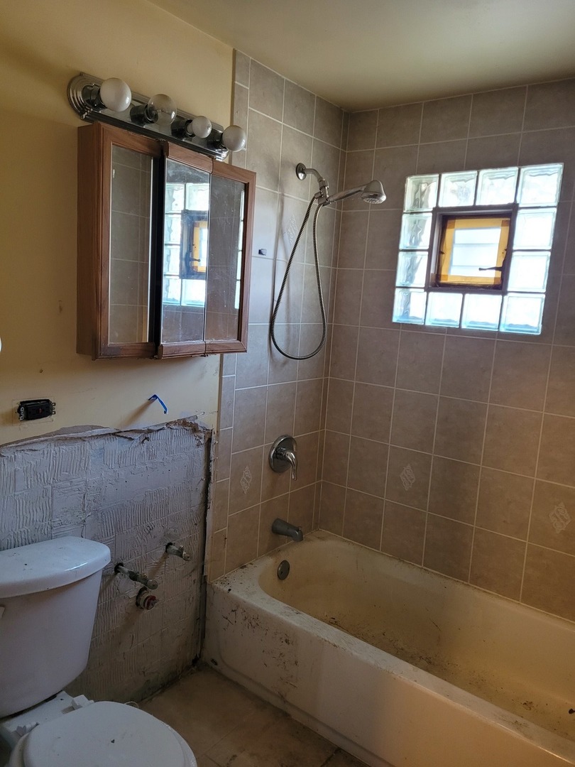 7911 45th Street Lyons, IL 60534 - Photo 9 of 15 a bathroom with a toilet bathtub and shower
