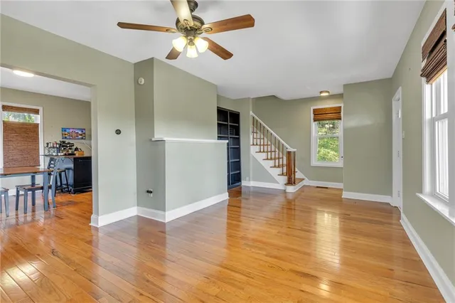 a view of a livingroom with wooden floor and a ceiling fan