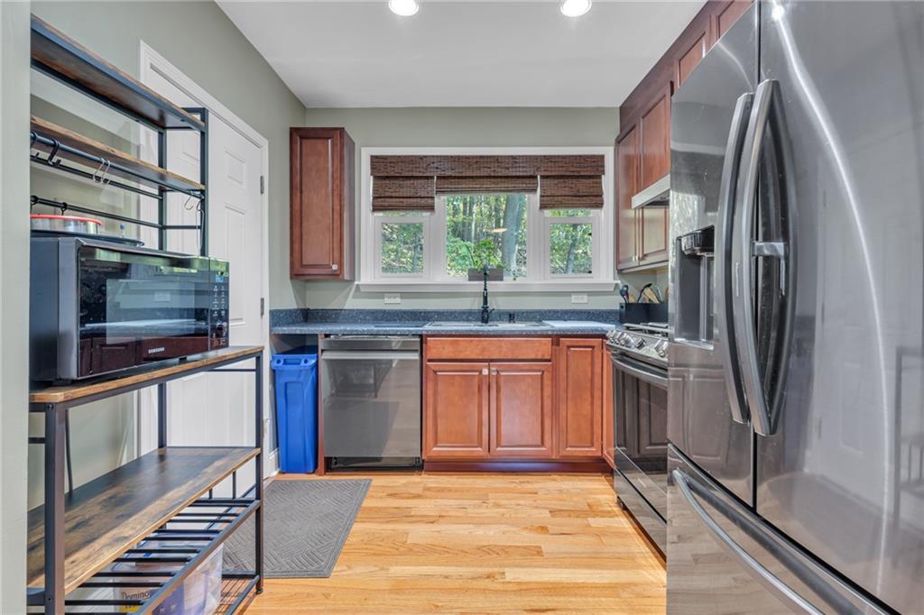 1205 Breitenstein Road Ambridge, PA 15003 - Photo 19 of 25 a kitchen with stainless steel appliances granite countertop a refrigerator a stove and a sink with wooden cabinets