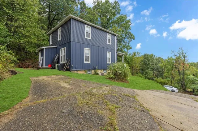 a brick house with a large tree in front of it