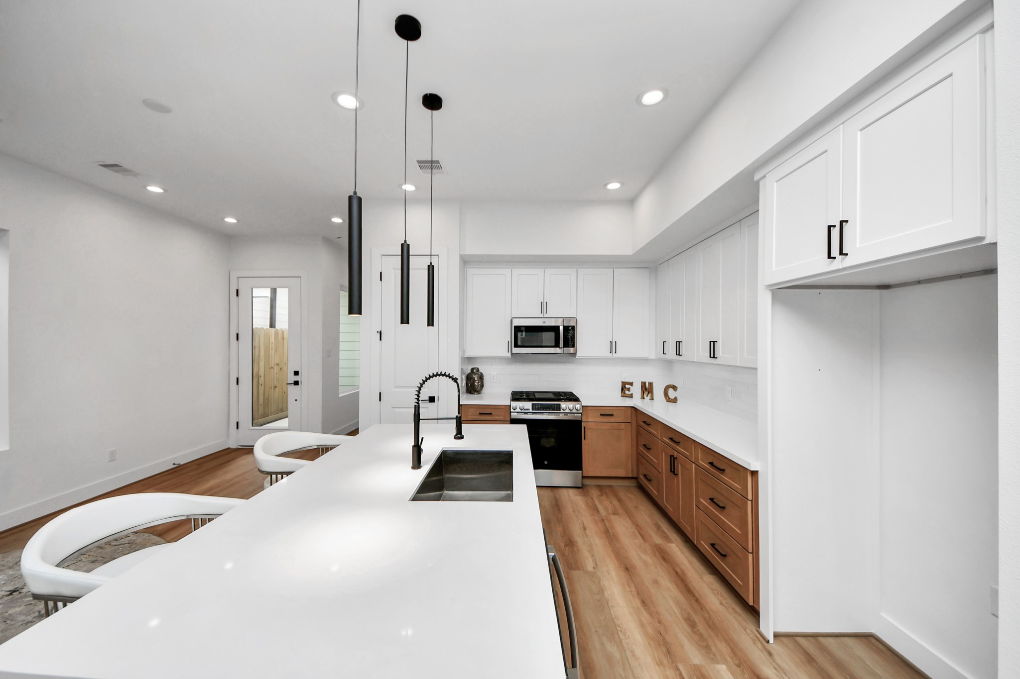 505 Middle Street Houston, TX 77003 - Photo 9 of 46 Discover a sleek, modern kitchen featuring gleaming stainless steel appliances, elegant white cabinetry, and a spacious island perfect for entertaining.