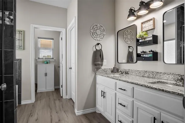 a bathroom with a granite countertop sink vanity and mirror