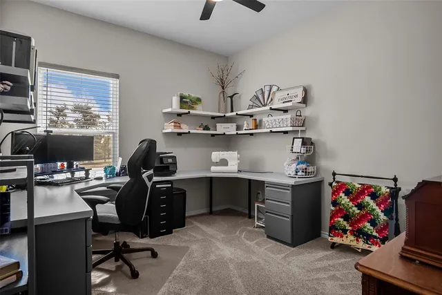 a view of a workspace with furniture and a window