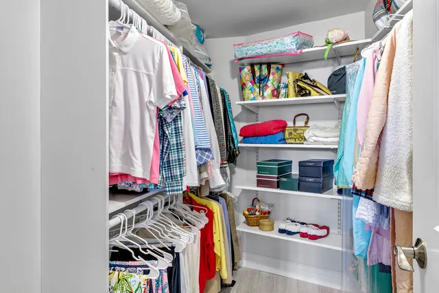 a view of walk in closet with clothes and shoes