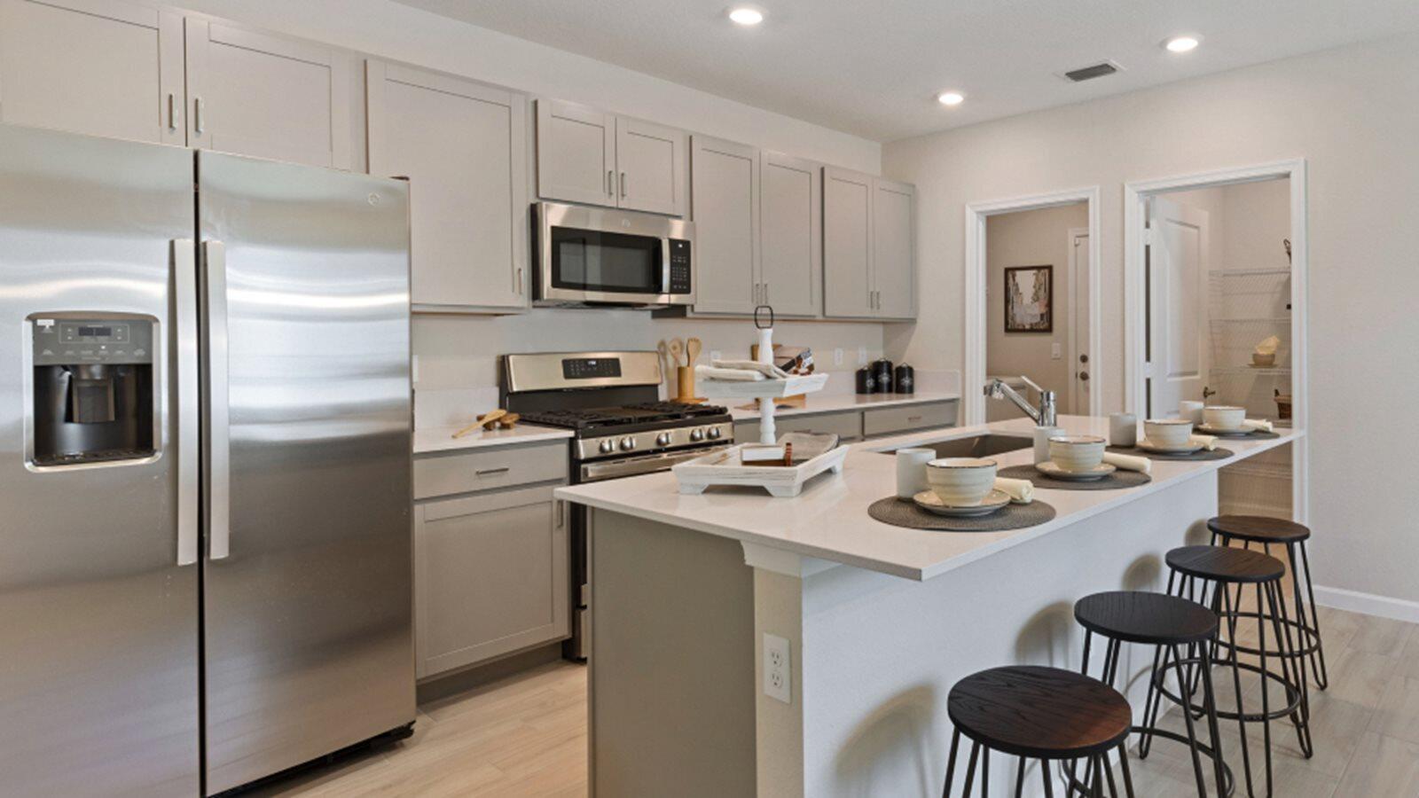 2211 Marigold Trail Palm Bay, FL 32907 - Photo 2 of 17 a kitchen with stainless steel appliances a sink a stove a refrigerator cabinets and dining table
