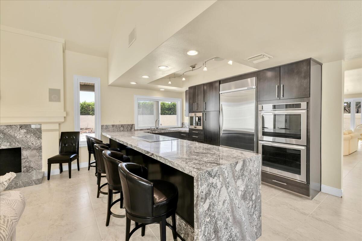 39 Santo Domingo Drive Rancho Mirage, CA 92270 - Photo 2 of 30 a kitchen with stainless steel appliances kitchen island granite countertop a table chairs sink and cabinets