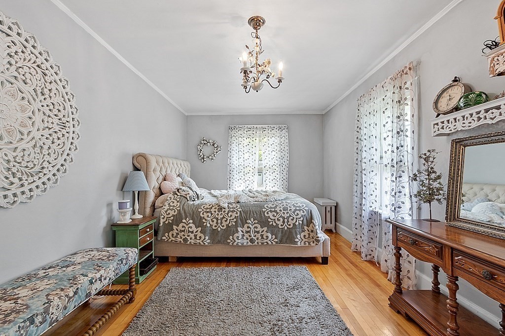 24 Maplewood Road Worcester, MA 01602 - Photo 21 of 42 a bed sitting in a bedroom next to a window with a chandelier