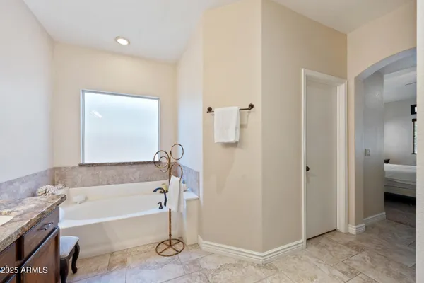 a bathroom with a sink double vanity granite tub and a mirror