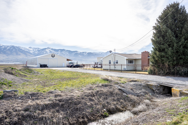 1981 South Main Street Lewiston, UT 84320 - Photo 16 of 47 View of yard with a mountain view, an outdoor structure, a pole building, and driveway