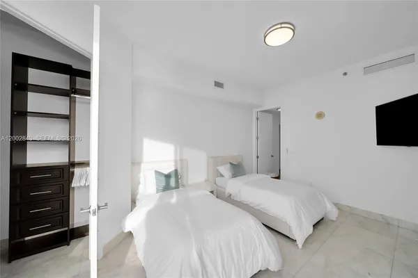 a bedroom with a bed and a flat tv screen in it