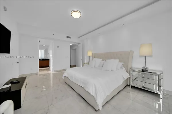 a bedroom with a bed and a flat screen tv