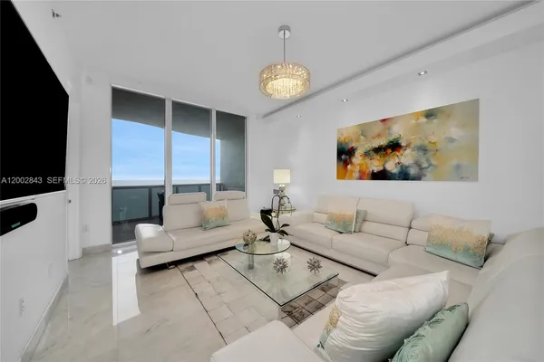 a living room with furniture a dining table and a flat screen tv
