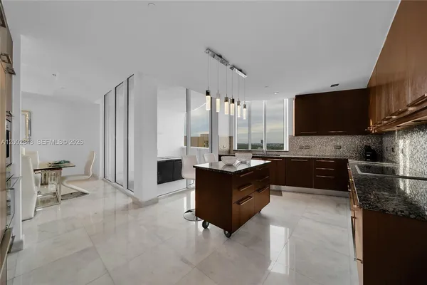 a large kitchen with kitchen island granite countertop a refrigerator and a stove top oven