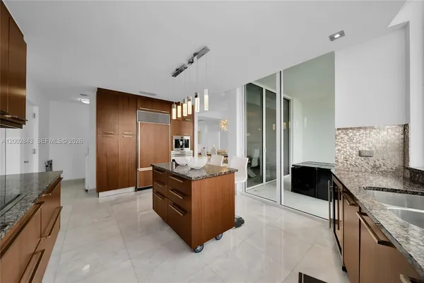 a kitchen with granite countertop a sink and a refrigerator