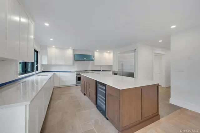 a large kitchen with stainless steel appliances kitchen island a large counter top and a stove top oven