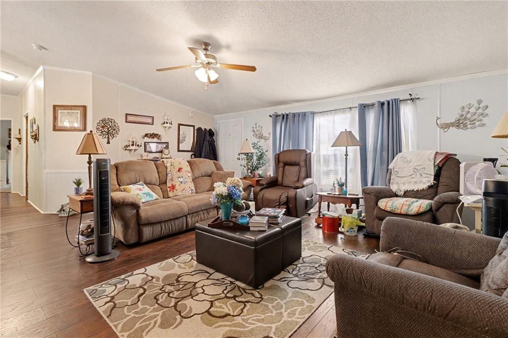 99 James Drive Hampton, GA 30228 - Photo 3 of 25 a living room with furniture a ceiling fan and a rug
