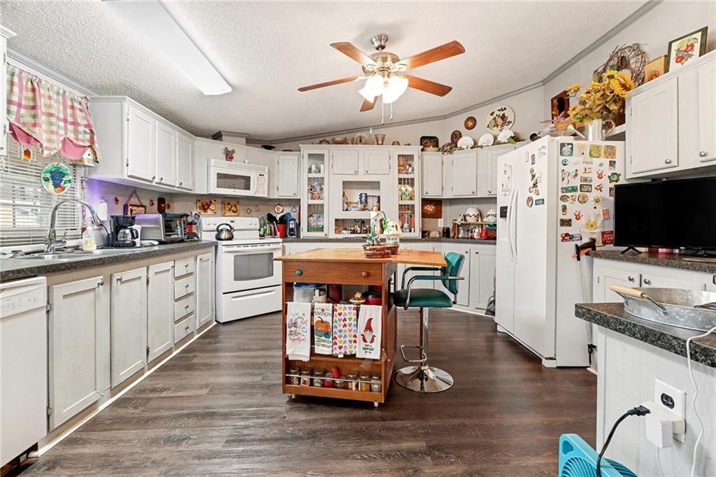 99 James Drive Hampton, GA 30228 - Photo 8 of 25 a kitchen with stainless steel appliances a stove a sink dishwasher and a refrigerator with wooden floor