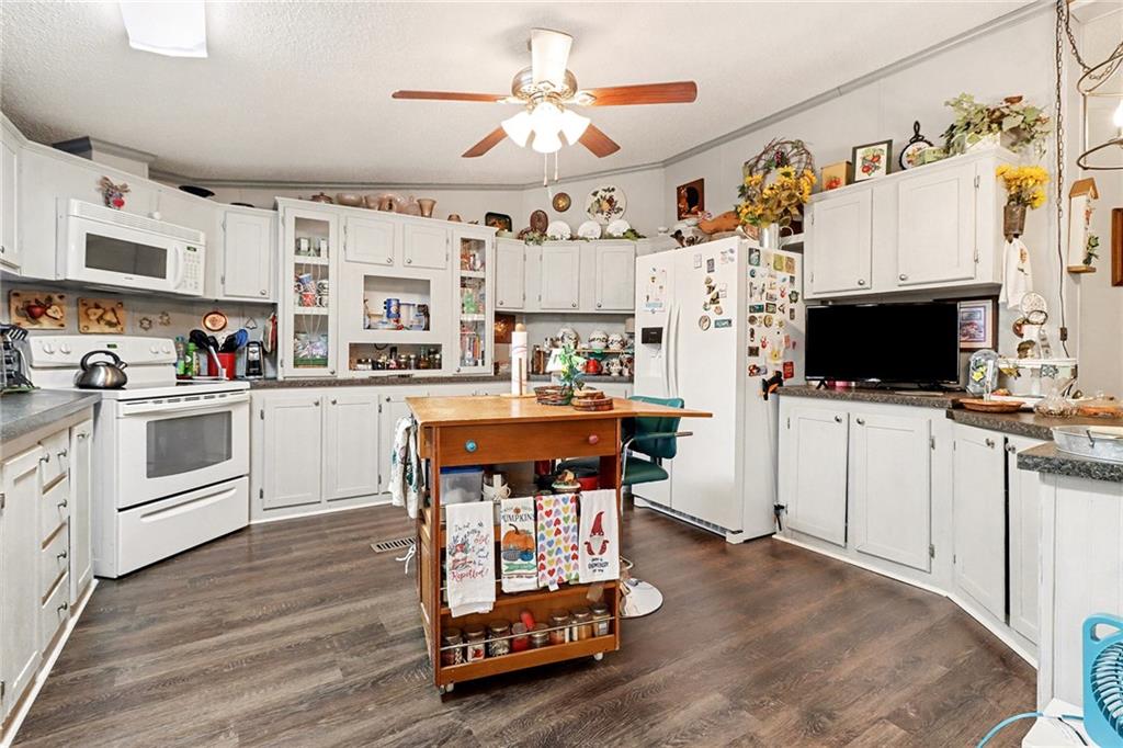 99 James Drive Hampton, GA 30228 - Photo 9 of 25 a kitchen with stainless steel appliances a stove a sink dishwasher and a fireplace with wooden floor