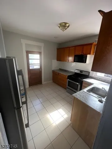 a view of kitchen with windows cabinet and microwave