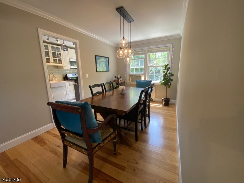 390 Morris Avenue, Unit 4 Summit, NJ 07901 - Photo 3 of 11 a dining room with furniture a chandelier and wooden floor