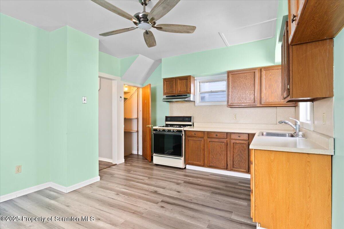 76 Mary Street Ashley, PA 18706 - Photo 12 of 30 a kitchen with granite countertop wooden floors stainless steel appliances and a window