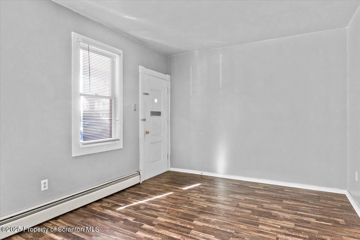 76 Mary Street Ashley, PA 18706 - Photo 6 of 30 a view of an empty room with wooden floor and a window