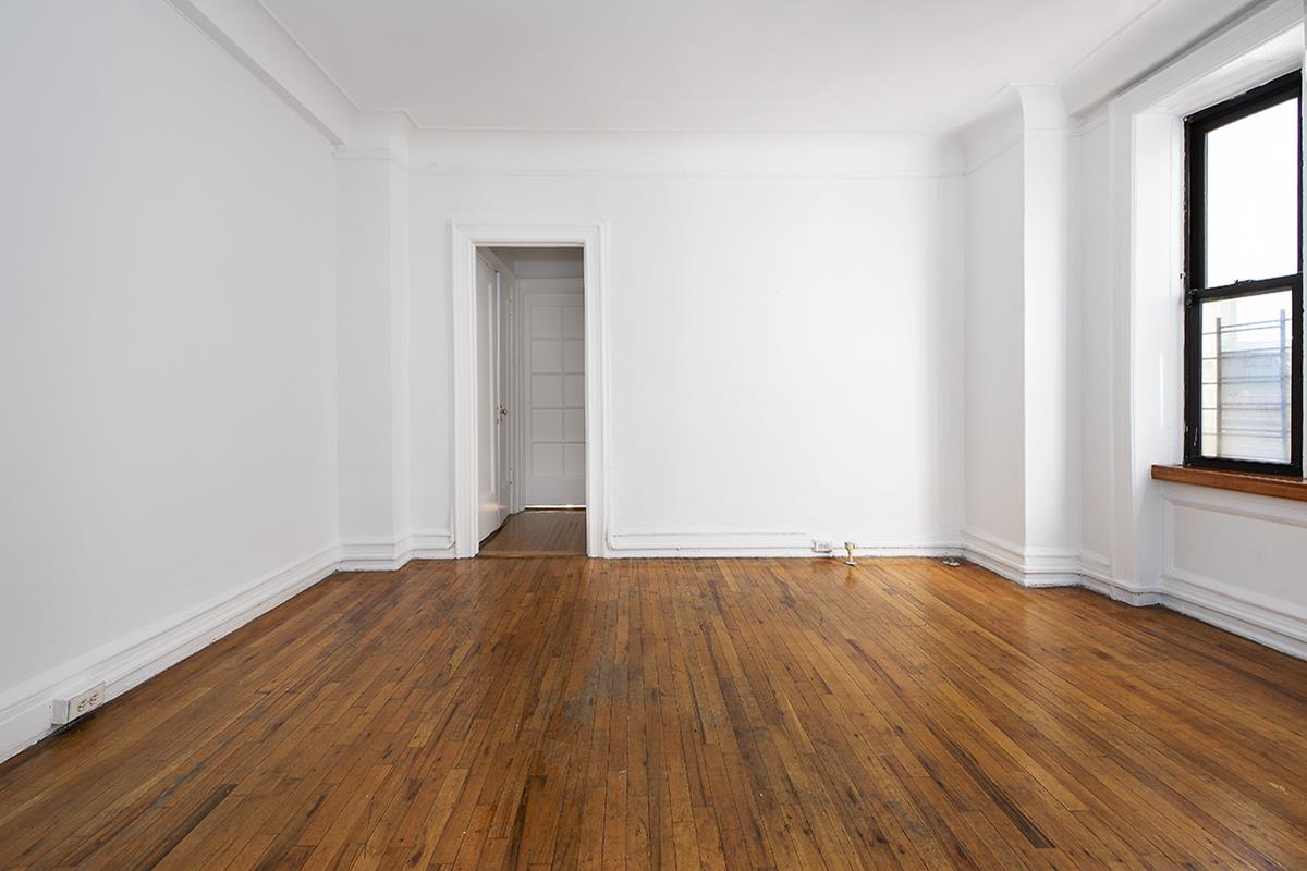 409 Edgecombe Avenue, Unit 1D Manhattan, NY 10032 - Photo 2 of 8 a view of an empty room with wooden floor and a window