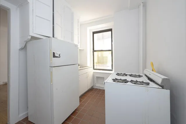 a white refrigerator freezer and a stove sitting inside of a kitchen