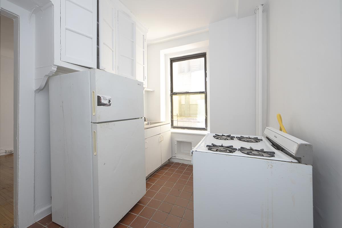 409 Edgecombe Avenue, Unit 1D Manhattan, NY 10032 - Photo 6 of 8 a white refrigerator freezer and a stove sitting inside of a kitchen