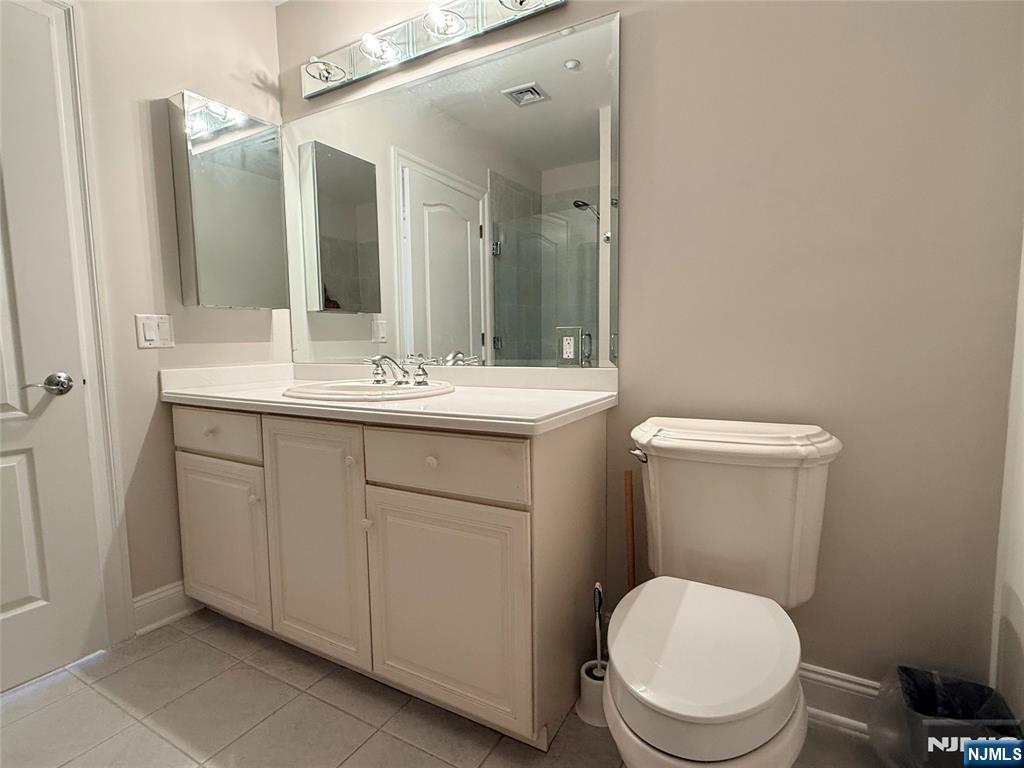 3104 Rio Vista Drive, Unit 3104 Mahwah, NJ 07430 - Photo 16 of 32 a bathroom with a toilet a sink and mirror