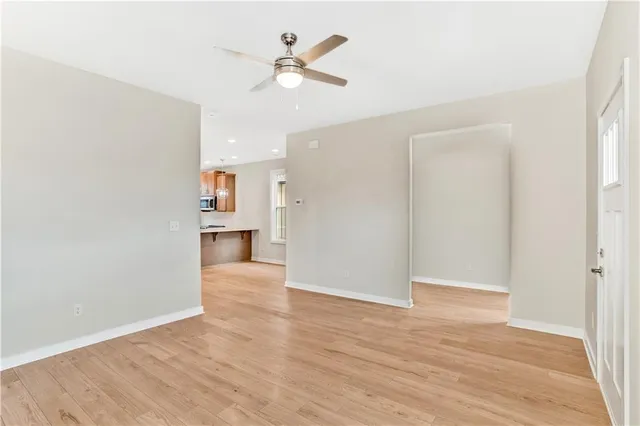 a view of a kitchen with wooden floor and a ceiling fan