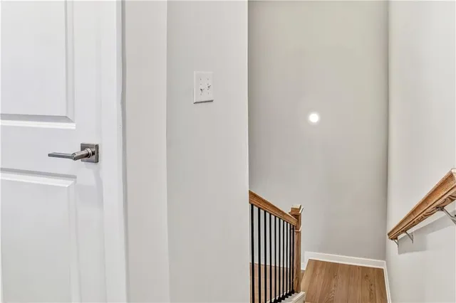 a view of a hallway with wooden floor and staircase