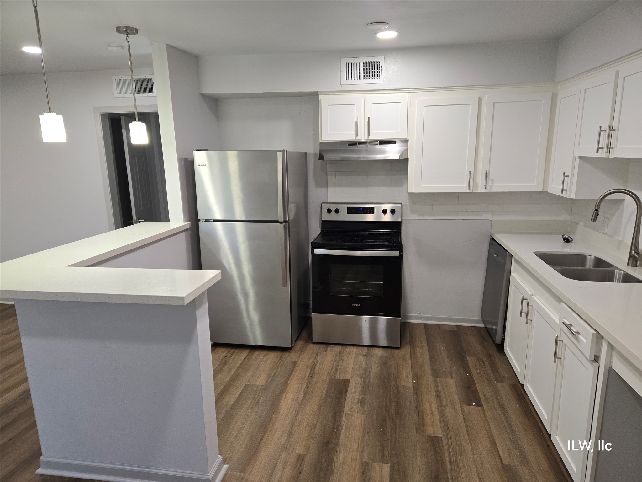 a kitchen with a sink a refrigerator and cabinets