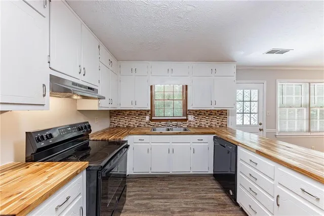 a kitchen with stainless steel appliances a sink stove and cabinets
