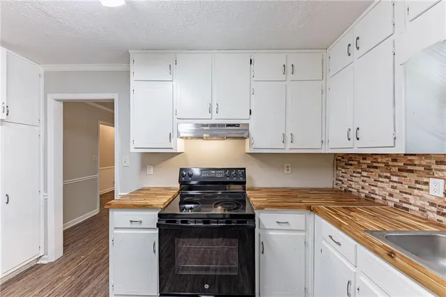 a kitchen with cabinets appliances and wooden floor