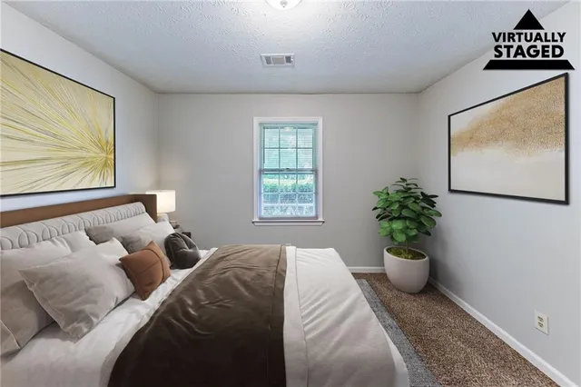 a bed sitting in a bedroom next to a window