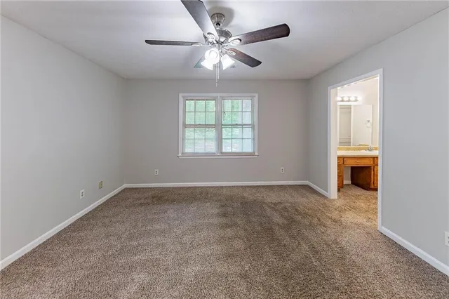 an empty room with windows and ceiling fan