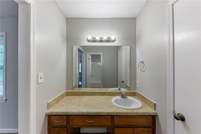 a bathroom with a granite countertop sink and a mirror