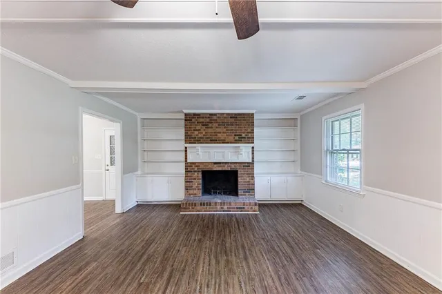 a living room with a fireplace and wooden floor