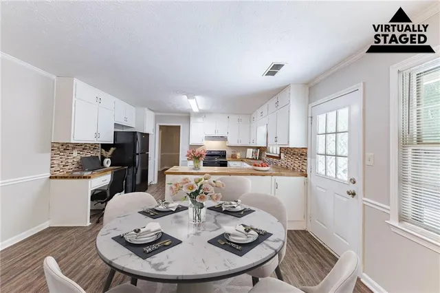 a kitchen with a refrigerator a stove a dining table and chairs