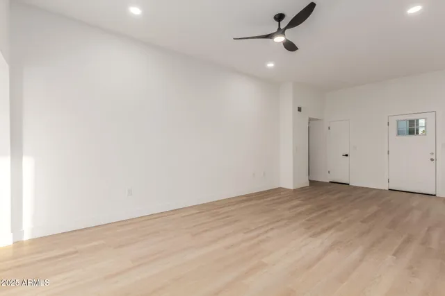 an empty room with a ceiling fan and window