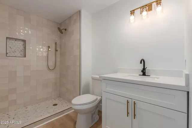 a bathroom with a sink a toilet and shower